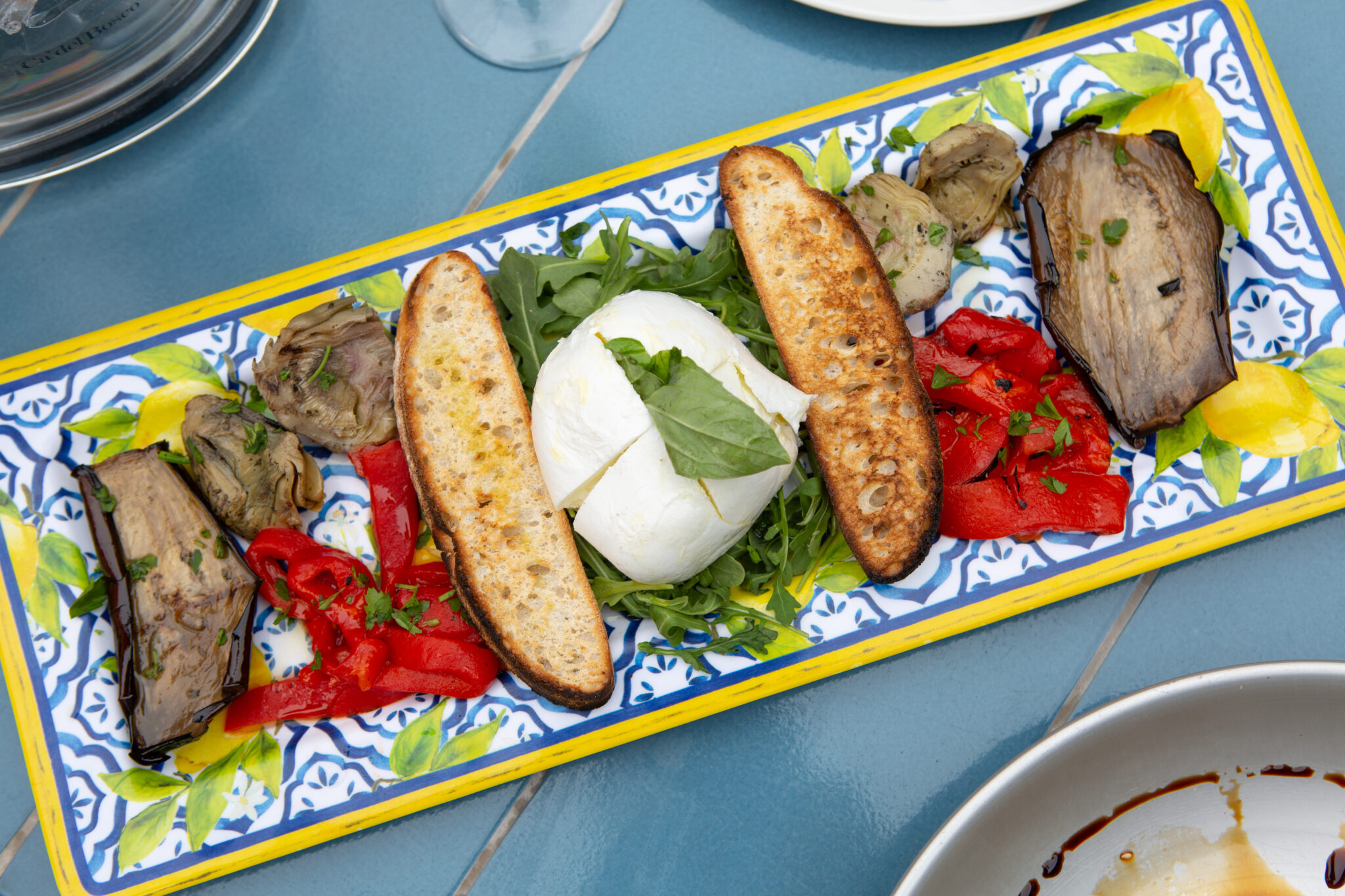 image of burrata, tomatoes and bread on an Italian plate