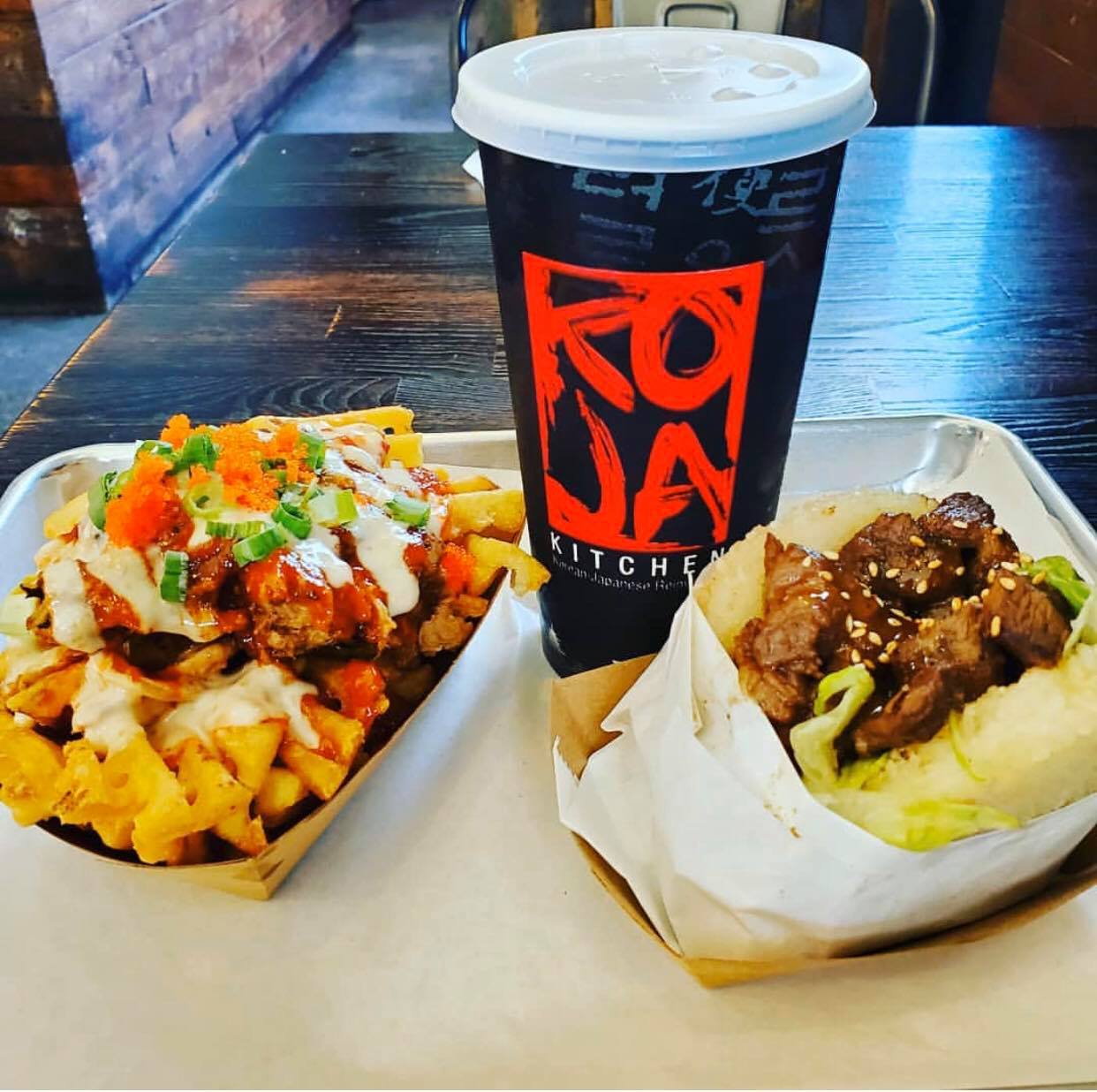 Korean-Japanese fusion meal of a "burger", loaded fries, and soda from Koja Kitchen.