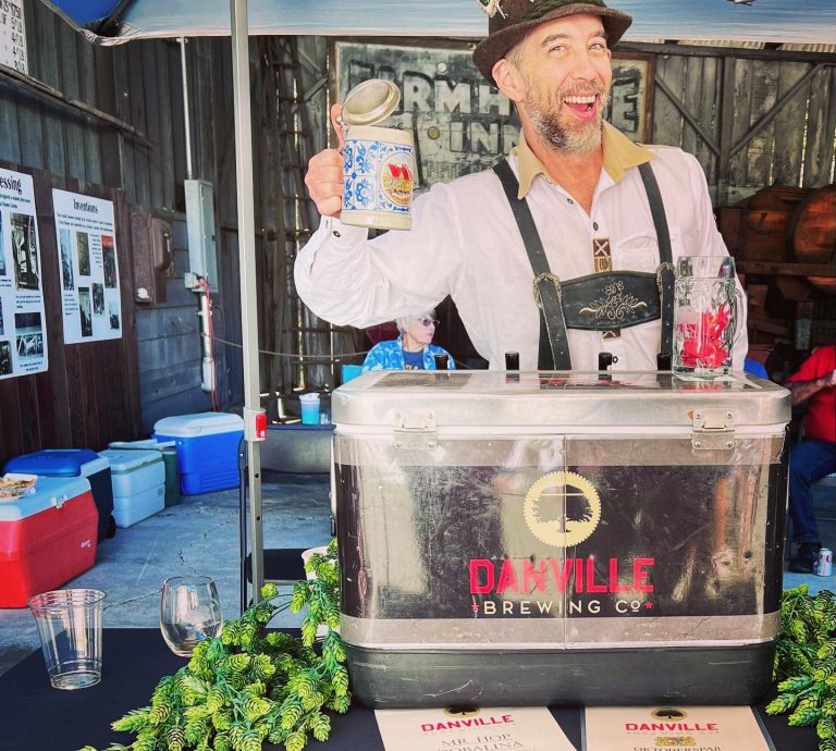 man in lederhosen celebrating oktoberfest by pouring beer celebrating